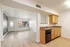 Bright and inviting open-concept living space with modern kitchen featuring sleek wooden cabinets and spacious countertops.