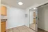 Bright and inviting room with elegant wooden flooring and mirrored closet doors, showcasing a sleek, modern finish.