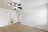 Bright, spacious bedroom with elegant ceiling fan, wood flooring, and en-suite bathroom, perfect for modern living.