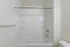 Pristine and elegant bathroom showcasing a glossy white bathtub with modern fixtures, ideal for relaxation and comfort.