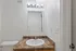 Modern bathroom featuring a sleek countertop, elegant sink, and well-lit mirror for a refreshing start to your day.
