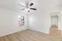 Bright apartment bedroom with elegant wood flooring and modern ceiling fan, offering plenty of natural light through a large window.