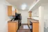 Modern kitchen with warm wooden cabinetry, sleek appliances, and elegant countertops, offering a cozy and inviting atmosphere.