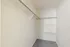 Spacious walk-in closet with multiple hanging rods and shelving, perfect for organized living.