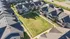 Charming aerial view of modern townhouses surrounding a lush central courtyard, showcasing inviting pathways and well-maintained landscaping.