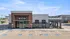 Modern restaurant exterior with stylish brick facade, ample outdoor seating, and accessible parking in a vibrant commercial area.
