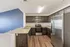 Modern kitchen with sleek granite countertops, stainless steel appliances, and rich wooden cabinetry against an accent blue wall.
