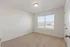 Bright and airy bedroom with plush carpet and large window offering natural light.