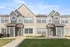 Charming townhouses showcasing modern architectural design with inviting entrances and pristine lawn in a vibrant neighborhood.