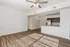Bright and inviting open-concept living space with hardwood floors, modern kitchen, and ceiling fan lighting.