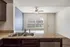 Modern kitchen interior with granite countertops, double sink, and stylish ceiling fan illuminating the space.