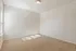 Bright, airy room with soft carpet and natural light from large windows, perfect for a cozy bedroom or office space.