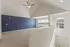 Bright and spacious loft area with a vaulted ceiling, elegant navy accent wall, and large windows offering scenic views.