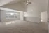 Bright and spacious carpeted room with vaulted ceilings and large windows, offering ample natural light and a cozy ambiance.
