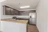 Modern kitchen showcasing elegant dark wood cabinets, sleek stainless steel appliances, and a polished granite countertop.