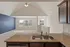 Inviting open-concept living area with vaulted ceilings and large windows, visible from the kitchen with elegant granite countertops.