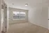 Bright and spacious room with plush carpeting and large window, perfect for a cozy bedroom or stylish home office.