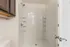 Modern bathroom with sleek walk-in shower and elegant shelving, offering a clean and spacious design.