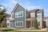 Elegant two-story apartment exterior with modern siding, large windows, and well-maintained landscaping under a clear blue sky.