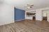 Charming open-concept living space with elegant wooden flooring, modern kitchen, and stylish blue accent wall.