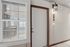 Inviting apartment entrance with elegant lighting, large window offering a glimpse of a cozy interior, and welcoming door at unit 209.