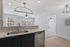 Modern kitchen with sleek countertops, a stylish hexagon backsplash, and open layout leading to a bright living room.