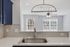 Modern kitchen with sleek white countertops, elegant hexagonal tile backsplash, and stylish stainless steel sink, leading into a bright living area with large windows and contemporary lighting.