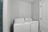 Bright and modern laundry area with efficient appliances set against clean, minimalistic design.