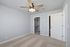Bright bedroom with plush carpet, ceiling fan, and a spacious walk-in closet, perfect for a cozy and organized living space.