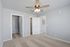 Bright, spacious bedroom with plush carpet, ceiling fan, and clean white doors leading to a closet and living area.