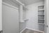 Spacious walk-in closet with sleek shelving and ample hanging space, perfect for organizing your wardrobe.
