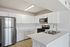 Sleek modern kitchen with stainless steel appliances, white cabinetry, and elegant quartz countertops.