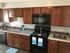 Newly remodeled kitchen with black appliances and dark brown cabinets