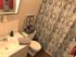 Bathroom with plank vinyl flooring and tile backsplash behind sink
