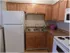 Newly remodeled kitchen with white appliances and light brown cabinets