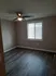 1 bedroom living room with large front window and VCT flooring in light gray