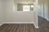 Elegant open space with modern wooden flooring, abundant natural light from large windows, and a cozy ceiling fan.