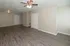 Spacious and inviting living area with modern hardwood flooring and elegant ceiling fan, perfect for comfortable living.