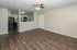Inviting open-concept living area with beautiful wood flooring and modern kitchen equipped with sleek appliances.