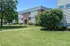 Charming residential apartment building surrounded by lush greenery, showcasing a serene and inviting neighborhood atmosphere.