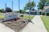 Welcome to Grey Ridge Apartments, featuring a stylish entry sign with vibrant landscaping under a clear blue sky.