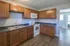 Bright and inviting kitchen with elegant wooden cabinets, modern appliances, and luxurious hardwood flooring.