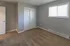 Bright and inviting bedroom with plush carpet, neutral walls, and a large window for natural light.
