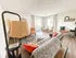 Inviting living room with cozy gray sofa, vibrant cushions, and a chic dining area by sunlit windows, perfect for elegant entertaining.