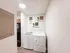 Bright laundry room featuring modern washer and dryer with chic shelving decor.