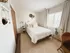 Bright and cozy bedroom with elegant decor, featuring a plush bed, stylish bedside table, and large window with serene views.