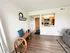 Inviting living space with sleek hardwood floors, cozy seating, and a view of the charming kitchen. Perfect blend of style and comfort for modern living.