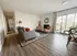 Bright and inviting living room with modern decor, featuring a cozy fireplace, stylish seating, and expansive glass doors opening to a scenic balcony.