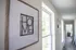Inviting hallway with large windows, natural light, and a stylish 'HOME' art piece, leading towards a cozy room.