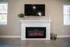 Modern living room with elegant white fireplace and mounted TV, featuring cozy electric flames and fresh greenery.